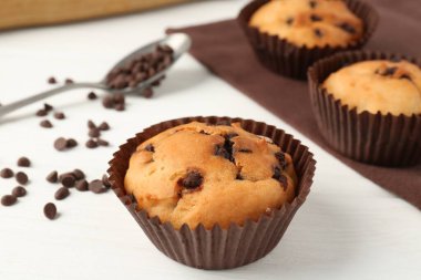 Beyaz ahşap masa üzerinde çikolata parçalı lezzetli kek, yakın plan.