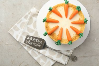 Açık gri masada ev yapımı havuçlu kek ve sunucu.