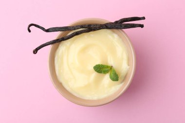 Lezzetli vanilyalı puding, nane ve kapsüller pembe arka planda, üst manzara