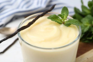 Lezzetli vanilyalı puding, nane ve kapsüller masada, yakın plan.