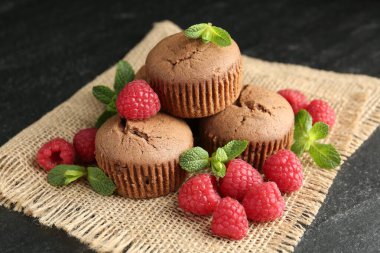 Ahududu ve nane aromalı nefis çörekler, koyu dokulu masa, yakın plan.