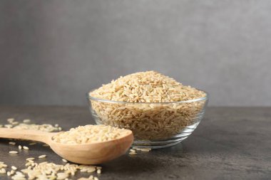 Kahverengi pirinç kasede ve kaşık gri masada. Metin için boşluk