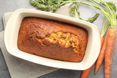 Lezzetli havuçlu kek ve sebzeler gri desenli masada, düz yatıyordu.