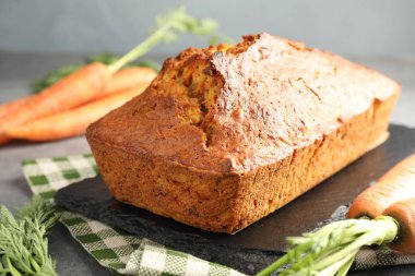 Gri desenli masada havuçlu kek ve sebzeler, yakın plan.