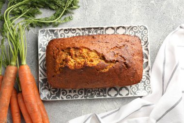 Lezzetli havuçlu kek ve sebzeler gri desenli masada, düz yatıyordu.