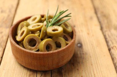 Lezzetli marine edilmiş zeytin halkaları ve ahşap masada biberiye, yakın plan. Metin için boşluk