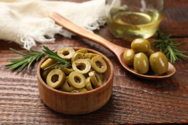 Lezzetli marine edilmiş zeytin halkaları ve biberiye ahşap masada, yakın plan.