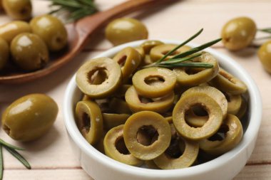 Lezzetli marine edilmiş zeytin halkaları ve biberiye açık ahşap masada, yakın plan.