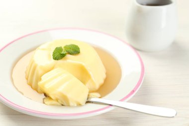 Karamel soslu lezzetli puding ve beyaz masada servis edilen nane şekeri.