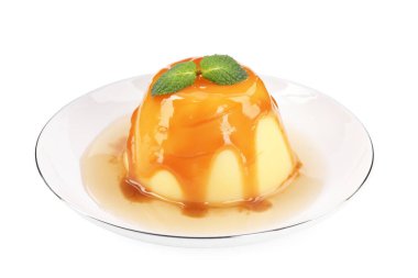 Karamel soslu lezzetli puding ve beyaz üzerine izole edilmiş nane.