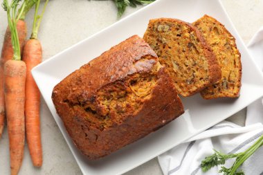 Açık gri masada fındıklı ve sebzeli ev yapımı havuçlu kek.