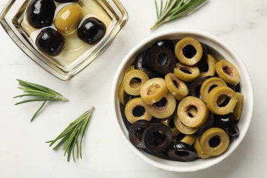 Farklı lezzetlerde marine edilmiş zeytin halkaları, tüm olanlar ve biberiye ışık masasında, düz yatıyordu.