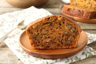 Ev yapımı havuçlu kek, fındıklı ve kaşıkla ahşap masa, yakın plan.