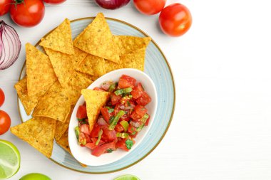 Lezzetli salsa (Pico de gallo) nachos ve ürünlerle beyaz ahşap masa üzerinde servis edilir. Metin için boşluk