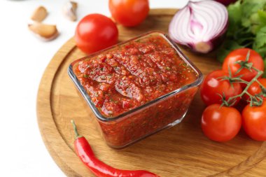 Lezzetli salsa sosu ve malzemeler beyaz masada, yakın plan.