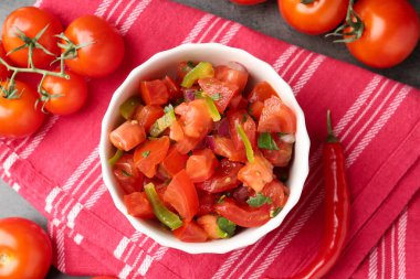 Lezzetli salsa (Pico de gallo) kasede ve biberli gri masada, düz yerde