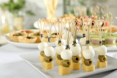 Beyaz masada bir sürü lezzetli kanepe, yakın plan.