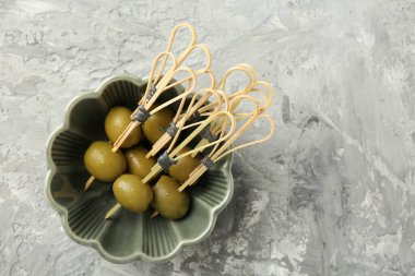 Gri dokuma masasında salamura edilmiş zeytin, üst manzara.