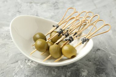 Gri dokulu masada salamura edilmiş zeytinler, yakın plan.