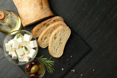 Lezzetli salamura zeytin, ekmek ve peynire siyah masada servis ediliyor. Metin için boşluk