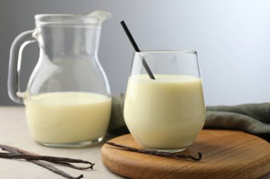 Gri masadaki lezzetli vanilyalı süt ve kapsüller