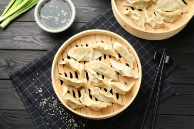 Lezzetli haşlanmış gyoza (hamur tatlısı) siyah ahşap masada servis edilir.