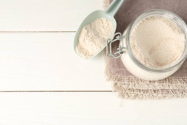 Коричневая рисовая мука на белом деревянном столе, плоская. Пространство для текста