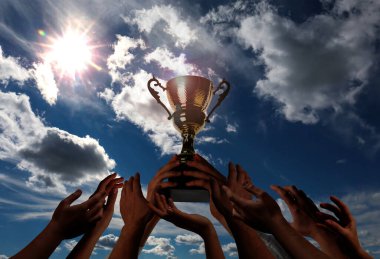 Altın kupa tutan adam ve gökyüzüne uzanan insanlar.