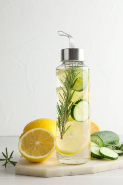 Şişe içinde limon suyu, biberiye, taze meyve ve salatalık.