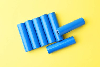 Sarı arka planda birçok AA hücre pili, üst görünüm