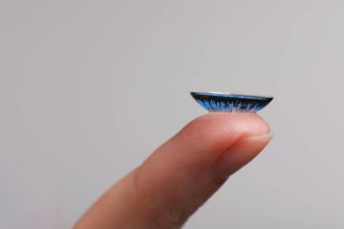 Gri arkaplanda mavi kontak lensli kadın, yakın plan