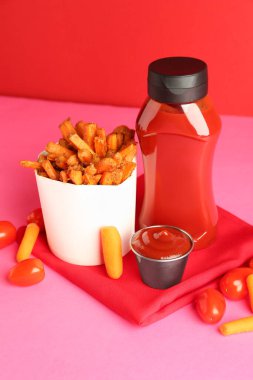 Tasty ketchup, tomatoes and fried carrots on color background clipart