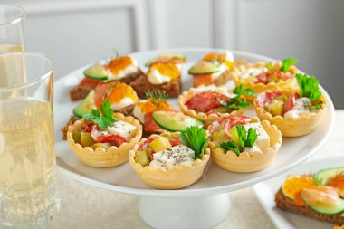 Birçok farklı lezzetli kanepe ve şarap beyaz masada, yakın plan.