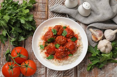 Lezzetli köfteler, soslu, pirinçli ve ahşap masadaki ürünler, düz konum.