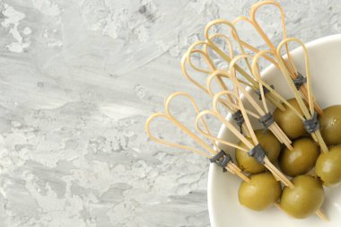 Gri dokuma masasında salamura edilmiş zeytinler, üst manzara. Metin için boşluk