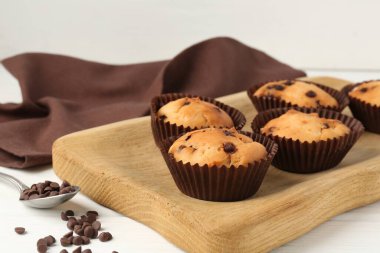 Beyaz ahşap masa üzerinde çikolata parçalı lezzetli kek, yakın plan.