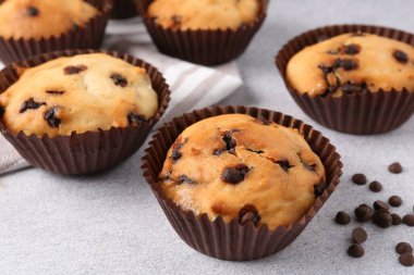 Açık gri masada çikolata parçalı lezzetli kek, yakın plan.