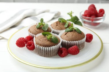 Beyaz masada ahududu ve nane şekerli lezzetli kekler, yakın plan.