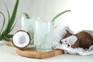 Beyaz desenli masa üzerinde hindistan cevizi ve aloe ile taze içecek.