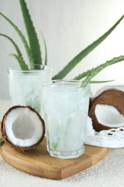 Beyaz desenli masa üzerinde hindistan cevizi ve aloe ile taze içecek.