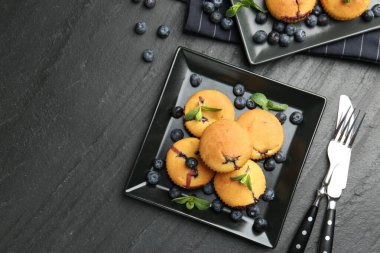 Yaban mersinli lezzetli kekler, nane ve çatal bıçak seti koyu dokulu masa, düz yatak. Metin için boşluk