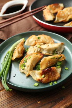 Ahşap masada lezzetli kızarmış gyoza (hamur tatlısı), yakın plan.