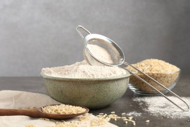 Esmer pirinç, un ve elek gri masada.