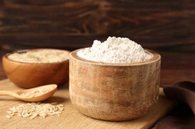 Kahverengi pirinç ve un ahşap masada, yakın plan.