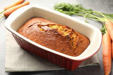 Gri desenli masada havuçlu kek ve sebzeler, yakın plan.