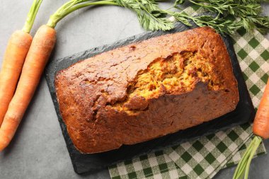 Lezzetli havuçlu kek ve sebzeler gri desenli masada, düz yatıyordu.