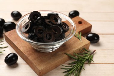 Lezzetli marine edilmiş zeytin halkaları, bütün olanlar ve biberiye açık ahşap masada, yakın plan.