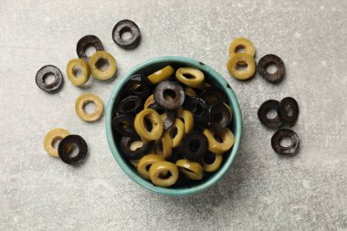 Gri desenli masa üzerinde salamura edilmiş farklı zeytin halkaları.