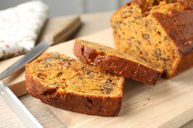 Ev yapımı havuçlu kek, fındıklı ve bıçaklı, ahşap masa, yakın plan.