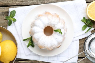 Lezzetli limonlu pasta pudra şekerli, taze meyveli ve nane şekerli ahşap masa, düz uzanmış.
